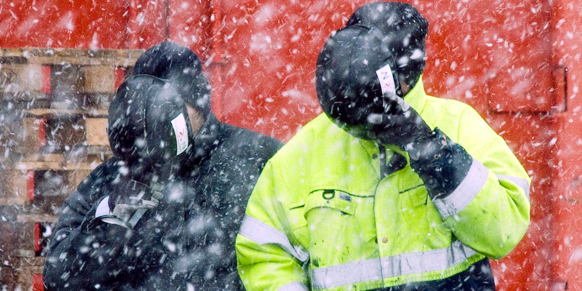 Två byggjobbare i snöoväder håller hjälmar för ansiktet som skydd. En ny svensk studie visar inom vilka yrken män har störst risk för självmord och självmordsförsök