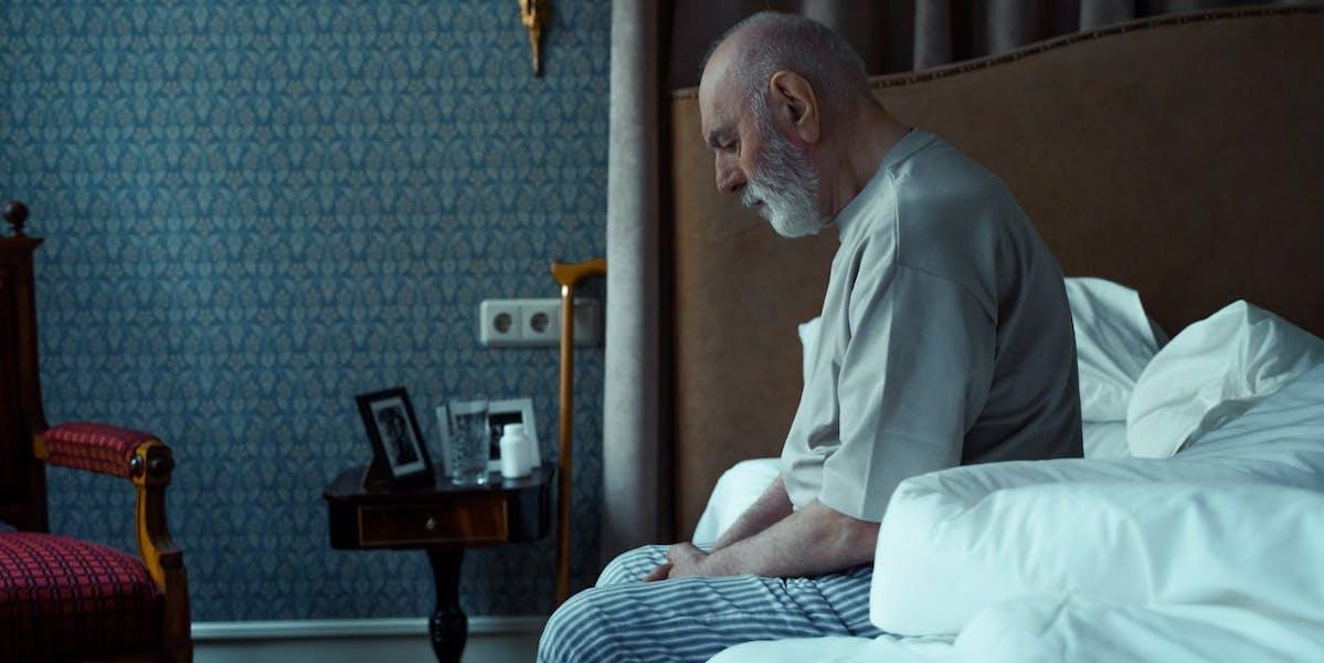 En ensam man sitter i sin säng. En ny studie visar att risken att dö för personer med cancer ökar av ensamhet eller social isolering.
